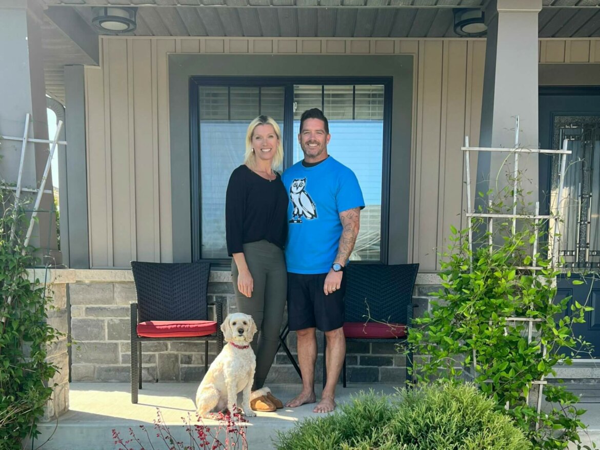 jennifer brinco and her husband stand in front of a house