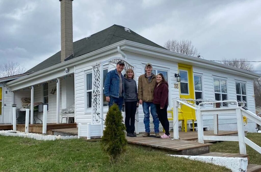 family standing in front of their home