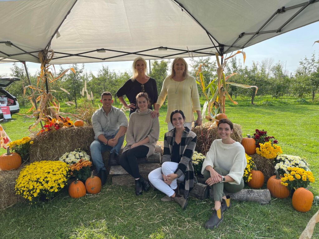 team members sit around fall festive scene