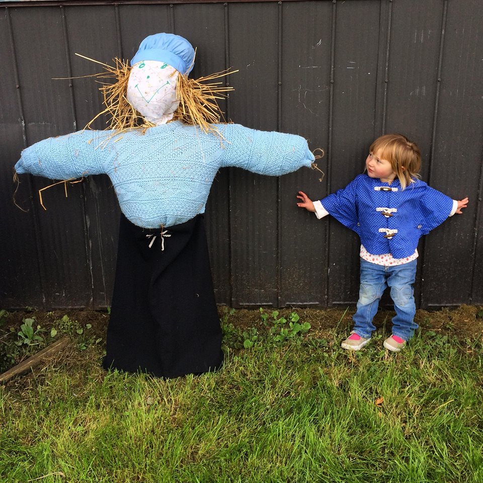 child and her scarecrow