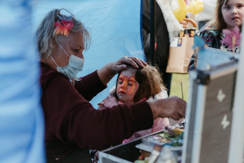 woman painting young child's face