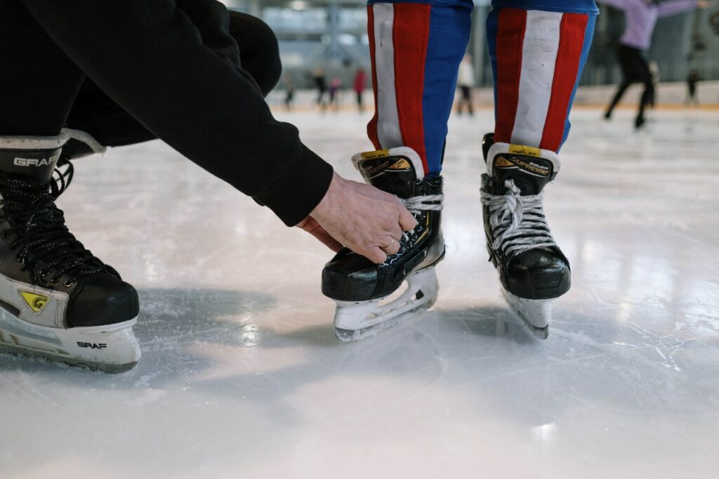 man tying skate laces for son