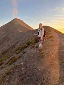 woman hikes a mountain at sunrise
