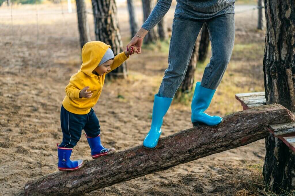 child playing on tree with mother