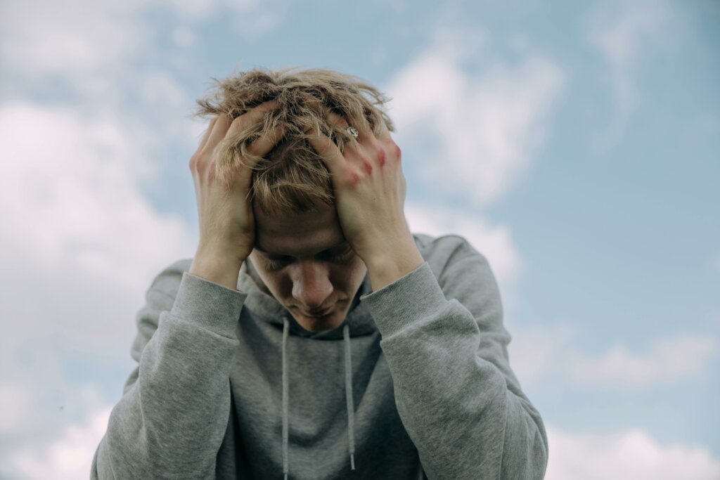 sad man with his head in his hands, worrying about mortgage rates