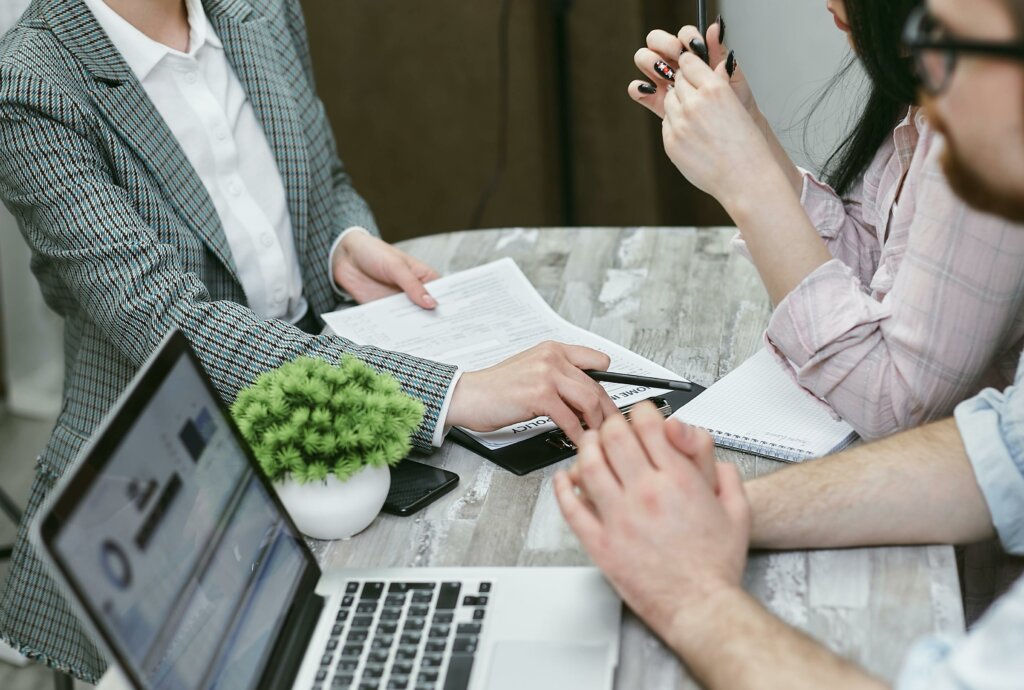 business woman giving couple their mortgage to sign