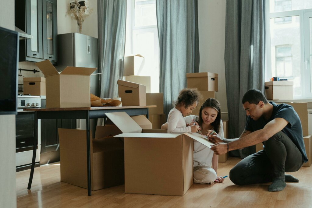 a young family packing up their things to move houses, cardboard boxes all around