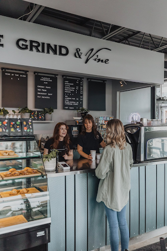 three women stand at the counter of a local cafe 