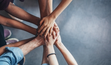 hands stacked on top of one another in solidarity 