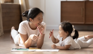 mum and daughter smiling and colouring